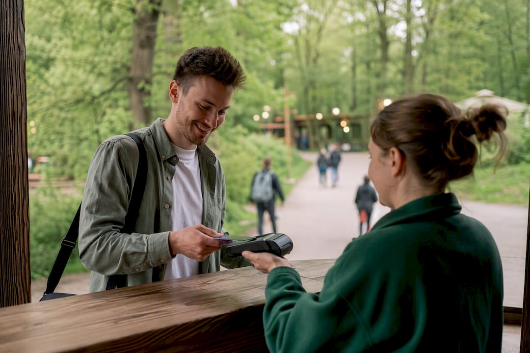 Une main utilisant un terminal à l'entrée d'un parc de loisirs